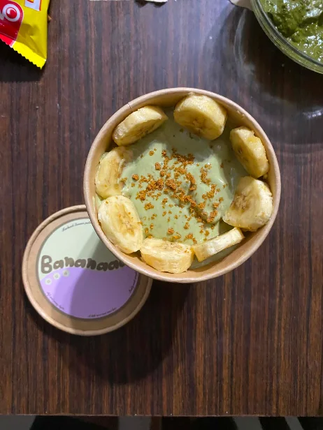 Matchanana, matcha dusted over cream, banana slices around the rim